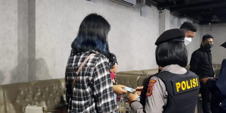 Tim kepolisian saat memeriksa identitas pengunjung saat razia Operasi pekat Siginjai di Angel Wing's Jambi. (Dok. Lamanesia.com)