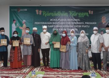 Dirut Bank Jambi dan anak yatim piatu yang diberikan bantuan sembako. (Dok. Istimewa)
