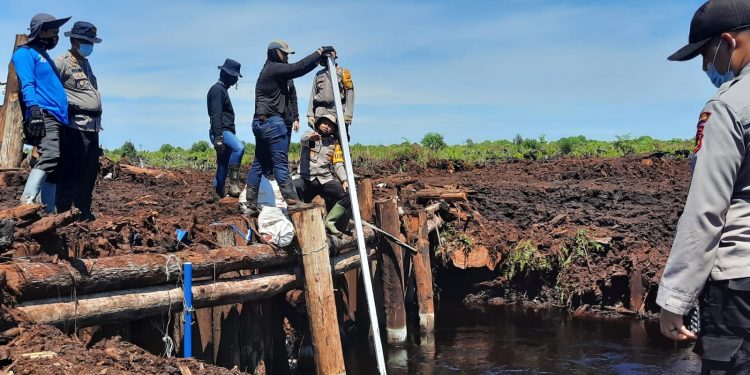 Kapolres Muaro Jambi AKBP Yuyan Priatmaja saat mengecek Sekat kanal untuk meminimalisir terjadinya Karhutla di Kabupaten Muaro Jambi. (Dok. Istimewa)