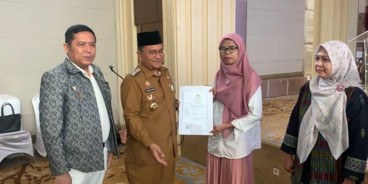 Wali Kota Jambi Maulana menyerahkan bantuan peralatan usaha dan sertifikat halal kepada pelaku UMKM binaan Pemkot Jambi, Senin (24/11/2025). (Dok: Rahmat)