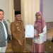 Wali Kota Jambi Maulana menyerahkan bantuan peralatan usaha dan sertifikat halal kepada pelaku UMKM binaan Pemkot Jambi, Senin (24/11/2025). (Dok: Rahmat)