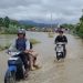 Debit Sungai Batang Merao meningkat tajam usai hujan deras semalaman, membuat warga di bantaran sungai siaga mengamankan barang-barang penting pada Kamis pagi (27/11/2025). (Dok: Rahmat)