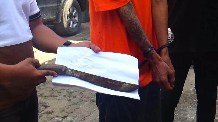 Petugas Polsek Kota Baru menunjukkan barang bukti sebilah golok yang digunakan pelaku penganiayaan di kawasan Tugu Keris Siginjai, Kota Jambi. Selasa 4 November 2025. (Dok: Rudi)