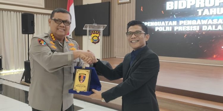 Kepala Perwakilan Ombudsman RI Provinsi Jambi, Saiful Roswandi, menerima plakat penghargaan dari perwakilan Polda Jambi usai memberikan materi Post Assessment di Aula Siginjai Polda Jambi, Jumat 14 November 2025. (Dok: Rahmat)