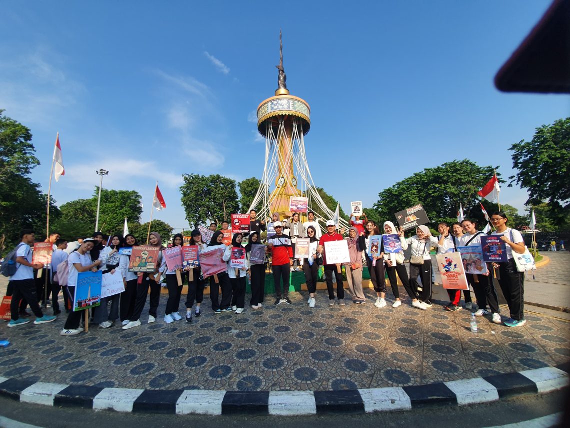 Ketua FKPT Provinsi Jambi, Dr. H. Abd. Rahman, S.Ag., M.Pd.I bersama peserta kampanye simpatik membentangkan spanduk bertema kebangsaan saat kegiatan Car Free Day di Kota Baru, Jambi, Minggu (26/10/2025). (Alpin)