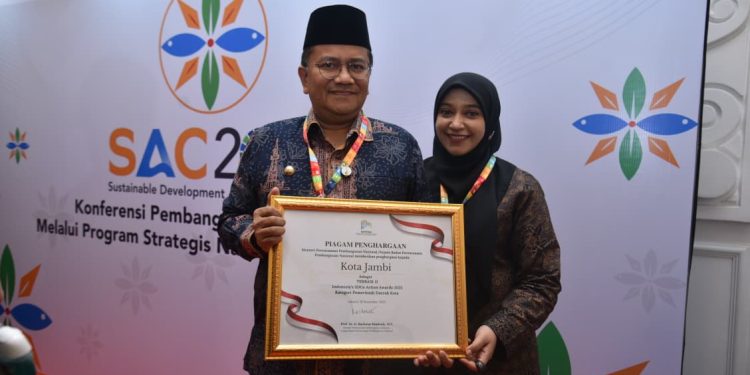Wali Kota Jambi Dr. dr. H. Maulana, MKM bersama Ketua TP-PKK Kota Jambi menerima Indonesian SDG Action Award 2025 di Kantor Kementerian PPN/Bappenas, Jakarta, Rabu (19/11/2025). (Dok:  Rudi)