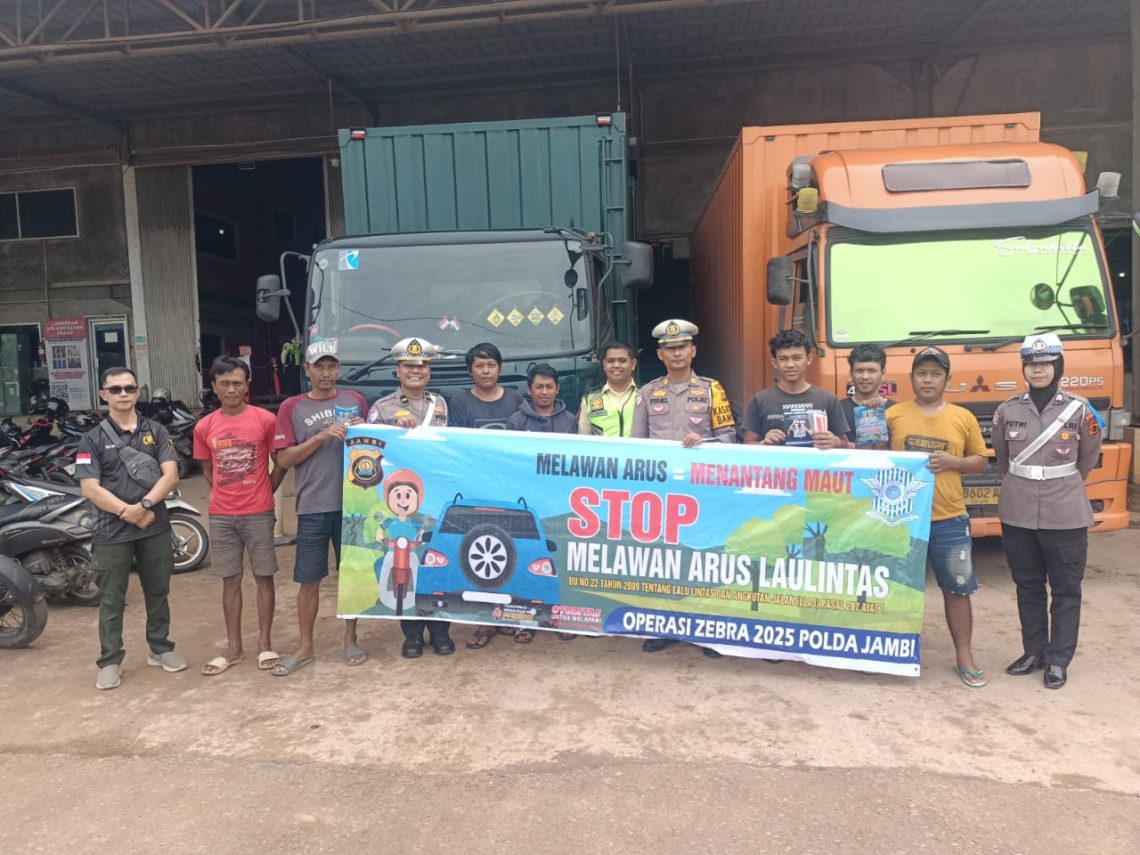 Petugas Satgas Preemtif Ops Zebra 2025 memberikan sosialisasi dan membagikan brosur keselamatan kepada para supir truk di Gudang Shopee, Jalan Lingkar Selatan, Kota Jambi, Minggu (23/11/2025). (Dok: Alpin)