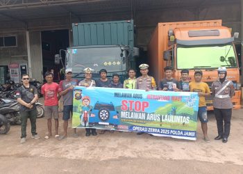 Petugas Satgas Preemtif Ops Zebra 2025 memberikan sosialisasi dan membagikan brosur keselamatan kepada para supir truk di Gudang Shopee, Jalan Lingkar Selatan, Kota Jambi, Minggu (23/11/2025). (Dok: Alpin)