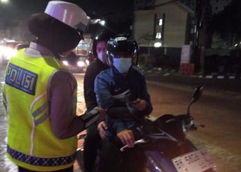 Petugas Satgas Preemtif Ops Zebra 2025 memberikan edukasi tertib berlalu lintas kepada pengendara di kawasan Simpang Jelutung, Kota Jambi, Sabtu malam (22/11/2025). (Dok: Alpin)