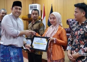 Bupati Merangin H. M. Syukur bersama Ketua TP PKK Lavita Syukur menyerahkan piagam penghargaan kepada tiga staf penyelamat Bilqis pada Rakor DRPPA di Aula Bappeda Merangin, Kamis (20 November 2025). (Dok: Diskominfo Merangin)