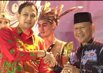 Wakil Bupati Merangin H A Khafid didampingi Wakil Ketua TP PKK Merangin Hj Minarsih Khafid, saat menerima piala pada malam puncak API Awards 2025, di Kabupaten Bengkayang Provinsi Kalimantan Barat. (Dok: Diskominfo Merangin)