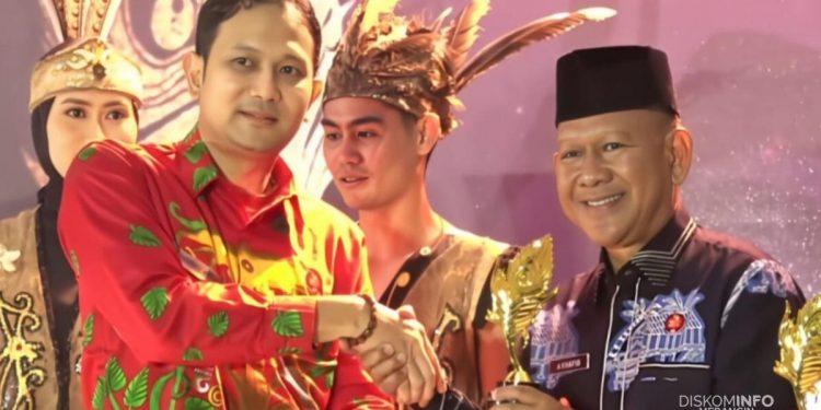 Wakil Bupati Merangin H A Khafid didampingi Wakil Ketua TP PKK Merangin Hj Minarsih Khafid, saat menerima piala pada malam puncak API Awards 2025, di Kabupaten Bengkayang Provinsi Kalimantan Barat. (Dok: Diskominfo Merangin)