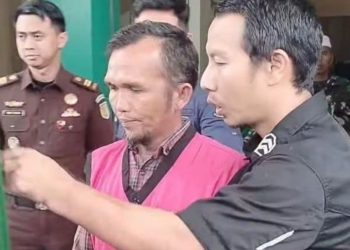 Penyidik Kejari Sungai Penuh menggiring tersangka IW, pendamping desa, usai ditetapkan sebagai tersangka kasus korupsi Dana Desa Batang Merangin TA 2021. (Dok: Alpin)