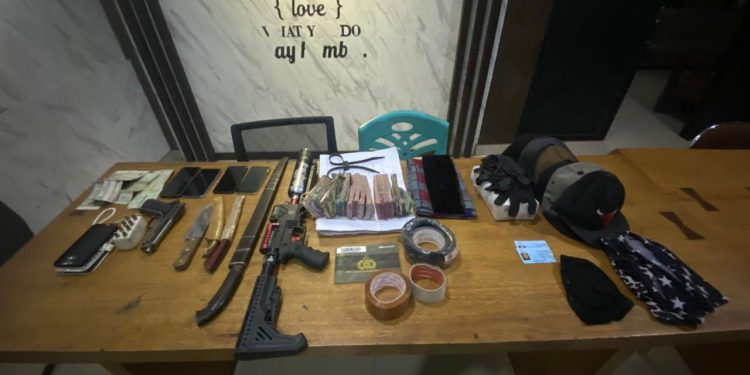 Barang bukti kasus perampokan bersenjata yang berhasil diamankan Sat Reskrim Polres Merangin, terdiri dari uang tunai, telepon genggam, kendaraan, perlengkapan penyamaran, dan senjata tajam. Foto diambil di Mapolres Merangin, Kamis (20/11/2025). (Dok: Rudi)