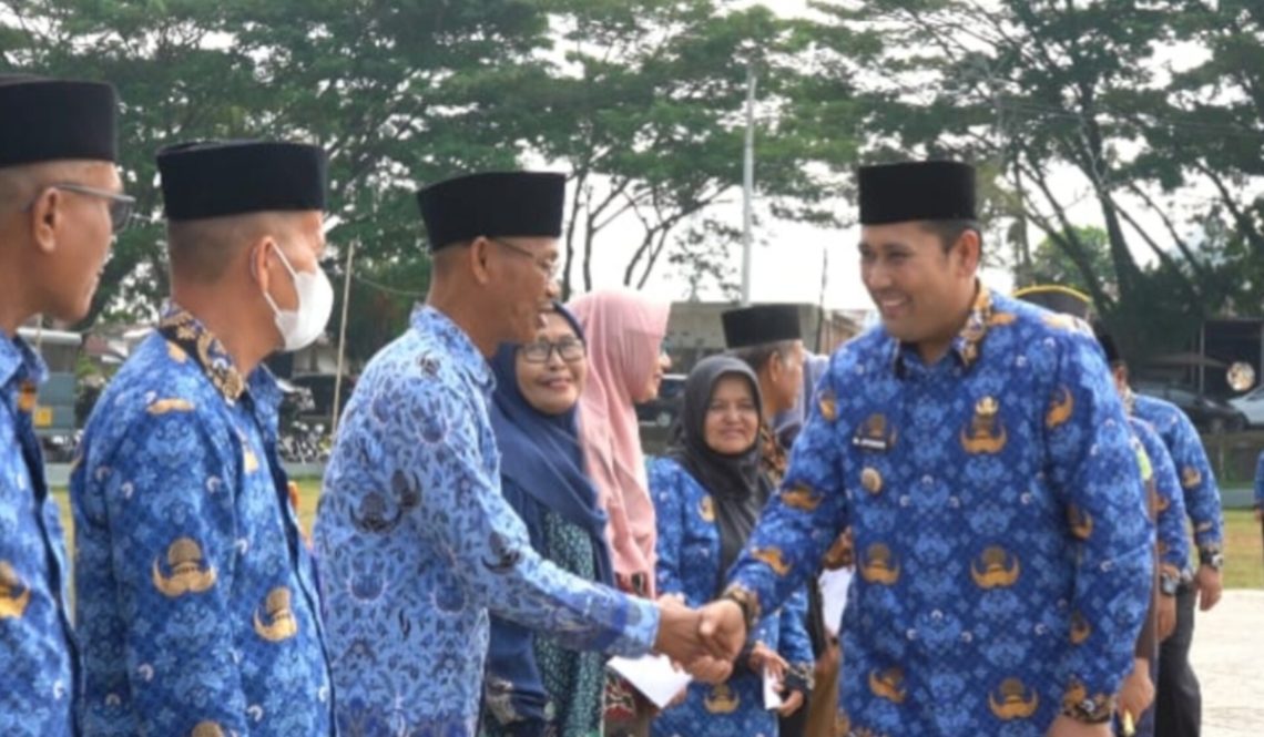 Bupati Merangin M. Syukur menyerahkan bantuan tali asih kepada pensiunan ASN dan uang duka kepada ahli waris anggota Korpri pada Apel Kesiapsiagaan HUT Korpri ke-54 di halaman Kantor Bupati Merangin, Senin (01/12/2025). (Dok: Rudi)