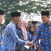 Bupati Merangin M. Syukur menyerahkan bantuan tali asih kepada pensiunan ASN dan uang duka kepada ahli waris anggota Korpri pada Apel Kesiapsiagaan HUT Korpri ke-54 di halaman Kantor Bupati Merangin, Senin (01/12/2025). (Dok: Rudi)