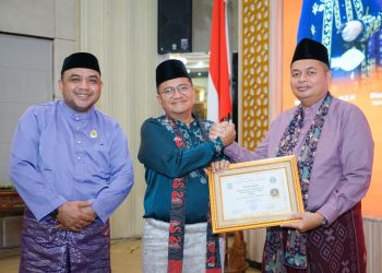 Ketua DPRD Kota Jambi Kemas Faried Alfarelly menerima penghargaan dari Wali Kota Jambi Dr. dr. H. Maulana pada malam penganugerahan Lomba Kampung Adat Tanah Pilih Pusako Batuah Kota Jambi Tahun 2025 di Aula Griya Mayang, Rumah Dinas Wali Kota Jambi. (Dok: Rahmat)