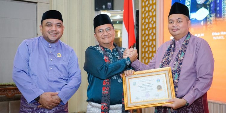 Ketua DPRD Kota Jambi Kemas Faried Alfarelly menerima penghargaan dari Wali Kota Jambi Dr. dr. H. Maulana pada malam penganugerahan Lomba Kampung Adat Tanah Pilih Pusako Batuah Kota Jambi Tahun 2025 di Aula Griya Mayang, Rumah Dinas Wali Kota Jambi. (Dok: Rahmat)