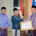 Ketua DPRD Kota Jambi Kemas Faried Alfarelly menerima penghargaan dari Wali Kota Jambi Dr. dr. H. Maulana pada malam penganugerahan Lomba Kampung Adat Tanah Pilih Pusako Batuah Kota Jambi Tahun 2025 di Aula Griya Mayang, Rumah Dinas Wali Kota Jambi. (Dok: Rahmat)