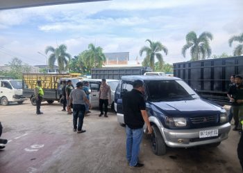 Petugas Polsek Kotabaru memeriksa kendaraan berbarcode MyPertamina yang tidak dapat menunjukkan STNK di SPBU Pall 7, Jalan Surya Dharma, Pall V, Kotabaru, Kota Jambi, Selasa (09/12/2025). (Dok: Alpin)