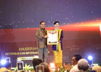 Ketua Komisi Informasi Pusat (KIP) Donny Yoesgiantoro memberikan penghargaan kepada Kepala Eksekutif Pengawas Perilaku Pelaku Usaha Jasa Keuangan, Edukasi dan Pelindungan Konsumen OJK Friderica Widyasari Dewi, Senin (15/12/2025) di Jakarta. (Dok: OJK)