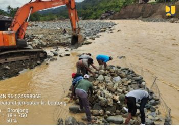 Pekerja dan alat berat Kementerian PU melakukan pemasangan jembatan Bailey pada Jembatan Teupin Mane sebagai akses utama Jalur Lintas Tengah Aceh pascabencana banjir dan longsor di Aceh Tengah. (Dok: Kementerian PU)