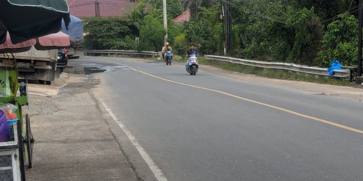 Arus lalu lintas di Jalur Lintas Timur Sumatera, Kecamatan Merlung, Kabupaten Tanjungjabung Barat, kembali lancar setelah banjir surut, dengan pengaturan lalu lintas oleh personel kepolisian di lapangan. (Dok: Alpin)