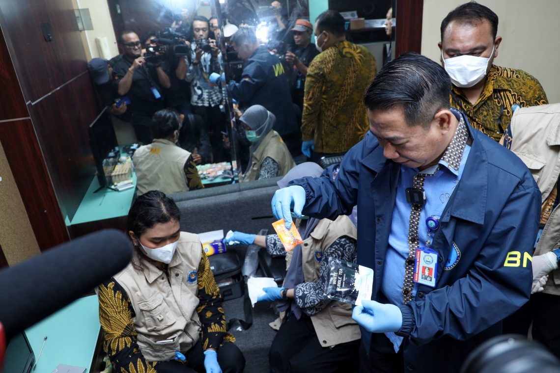 Petugas BNN bersama Bea dan Cukai serta Imigrasi menunjukkan barang bukti liquid vape dan kemasan sachet minuman energi yang mengandung narkotika hasil pengungkapan jaringan internasional di Bandara Soekarno-Hatta, Tangerang, Banten. (Dok: Humas BNN RI)
