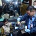 Petugas BNN bersama Bea dan Cukai serta Imigrasi menunjukkan barang bukti liquid vape dan kemasan sachet minuman energi yang mengandung narkotika hasil pengungkapan jaringan internasional di Bandara Soekarno-Hatta, Tangerang, Banten. (Dok: Humas BNN RI)
