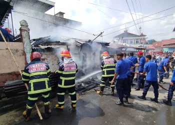 Petugas pemadam kebakaran berjibaku memadamkan api yang melahap sebuah rumah di kawasan pemukiman padat Jalan Bangau I, Kecamatan Jambi Selatan, Rabu (28/1/2026). (Dok: Alpin)
