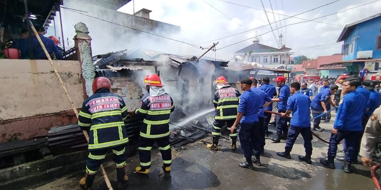 Petugas pemadam kebakaran berjibaku memadamkan api yang melahap sebuah rumah di kawasan pemukiman padat Jalan Bangau I, Kecamatan Jambi Selatan, Rabu (28/1/2026). (Dok: Alpin)