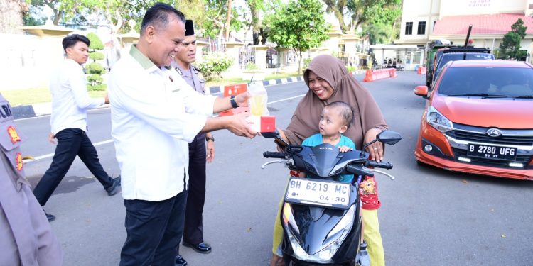 Dirreskrimsus Polda Jambi Kombes Pol Taufik Nurmandia saat memberikan takjil kepada pengendara yang melintas di Mapolda Jambi. (Dok: Alpin)