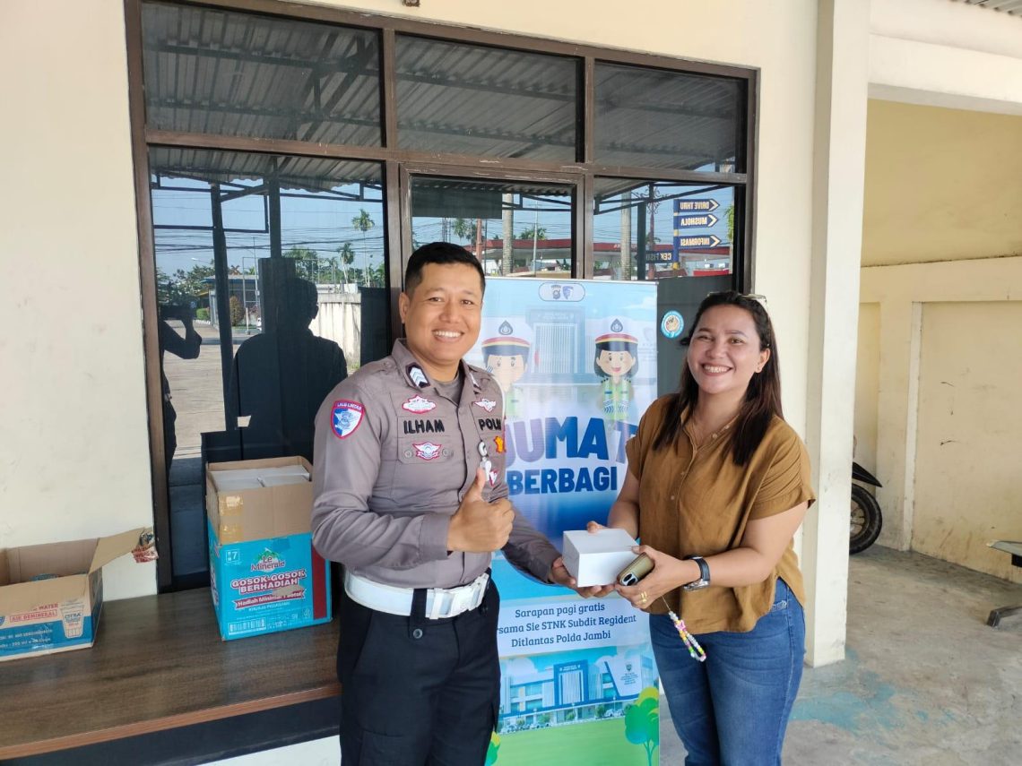 Personel Sie STNK Ditlantas Polda Jambi membagikan makanan gratis kepada wajib pajak di area Samsat Kota Jambi dalam kegiatan Jumat Berkah, Jumat (24/4/2026). (Dok: Alpin)