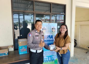 Personel Sie STNK Ditlantas Polda Jambi membagikan makanan gratis kepada wajib pajak di area Samsat Kota Jambi dalam kegiatan Jumat Berkah, Jumat (24/4/2026). (Dok: Alpin)