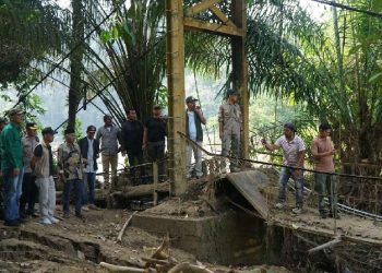 Bupati Sarolangun H. Hurmin bersama Forkopimda meninjau jembatan gantung rusak akibat banjir di Kecamatan Batang Asai yang direncanakan segera dibangun ulang. (Dok: Diskominfo Sarolangun)