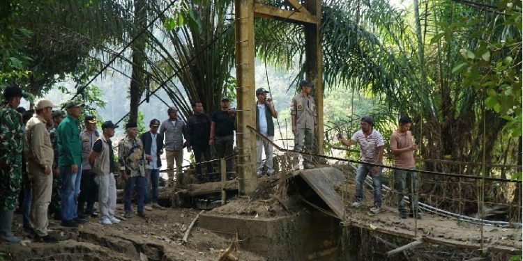 Bupati Sarolangun H. Hurmin bersama Forkopimda meninjau jembatan gantung rusak akibat banjir di Kecamatan Batang Asai yang direncanakan segera dibangun ulang. (Dok: Diskominfo Sarolangun)
