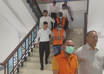 Mantan Kadisdik Provinsi Jambi Varial Adhi Putra bersama dua tersangka lain saat digiring petugas ke Rutan Mapolda Jambi. (Dok: Alpin)