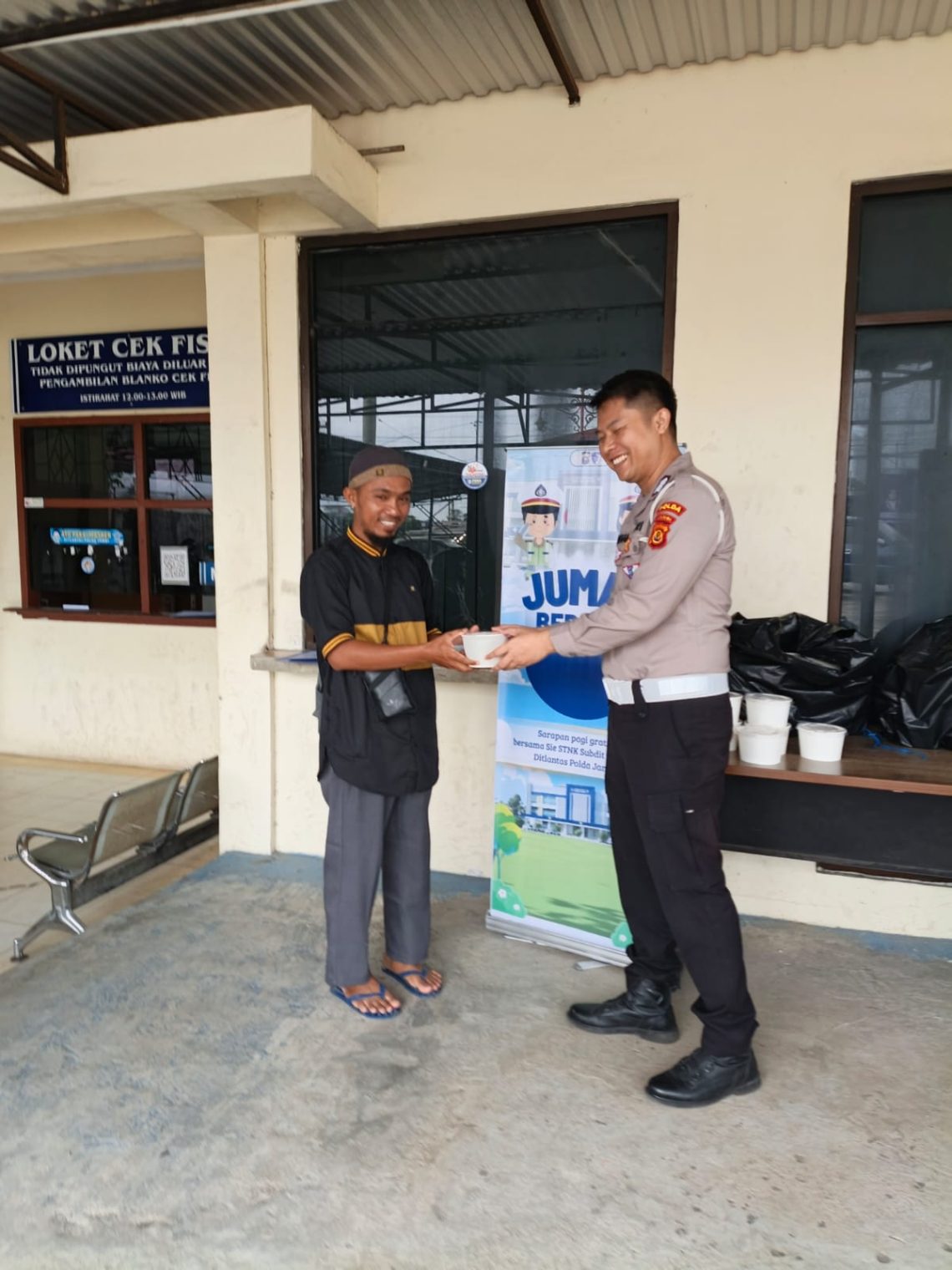 Personel Sie STNK Subdit Regident Ditlantas Polda Jambi membagikan makanan gratis kepada masyarakat wajib pajak dalam kegiatan “Jumat Berkah Jumat Berbagi” di Samsat Kota Jambi, Jumat (8/5/2026). (Dok: Alpin)