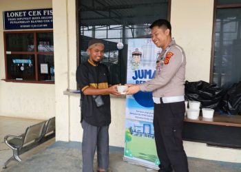 Personel Sie STNK Subdit Regident Ditlantas Polda Jambi membagikan makanan gratis kepada masyarakat wajib pajak dalam kegiatan “Jumat Berkah Jumat Berbagi” di Samsat Kota Jambi, Jumat (8/5/2026). (Dok: Alpin)