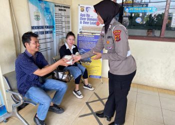 Personel Sie STNK Subdit Regident Ditlantas Polda Jambi saat membagikan makanan gratis kepada wajib pajak, petugas SPBU, dan masyarakat dalam kegiatan Jumat Berkah di kawasan Samsat Kota Jambi, Jumat (22/5/2026). (Dok: Alpin)