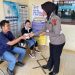 Personel Sie STNK Subdit Regident Ditlantas Polda Jambi saat membagikan makanan gratis kepada wajib pajak, petugas SPBU, dan masyarakat dalam kegiatan Jumat Berkah di kawasan Samsat Kota Jambi, Jumat (22/5/2026). (Dok: Alpin)