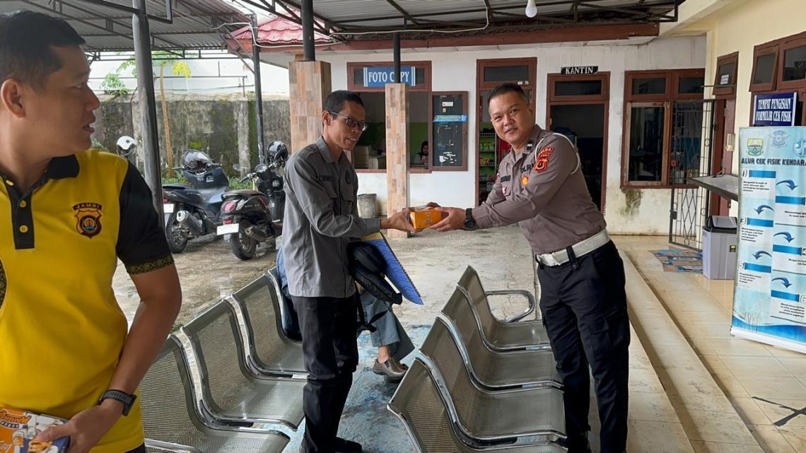 Personel Sie STNK Subdit Regident Ditlantas Polda Jambi membagikan makanan gratis kepada masyarakat wajib pajak di Samsat Kota Jambi dalam kegiatan Jumat Berkah Jumat Berbagi, Jumat (29/5/2026). (Dok: Alpin)