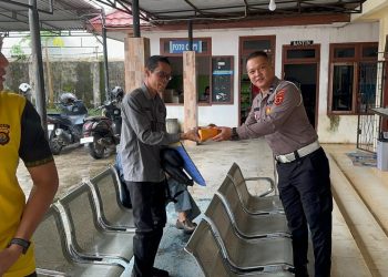 Personel Sie STNK Subdit Regident Ditlantas Polda Jambi membagikan makanan gratis kepada masyarakat wajib pajak di Samsat Kota Jambi dalam kegiatan Jumat Berkah Jumat Berbagi, Jumat (29/5/2026). (Dok: Alpin)