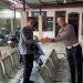 Personel Sie STNK Subdit Regident Ditlantas Polda Jambi membagikan makanan gratis kepada masyarakat wajib pajak di Samsat Kota Jambi dalam kegiatan Jumat Berkah Jumat Berbagi, Jumat (29/5/2026). (Dok: Alpin)