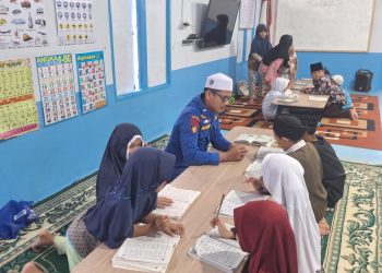 Personel Ditpolairud Polda Jambi bersama anak-anak mengikuti kegiatan mengaji di Rumah Baca Bhayangkara Bahari di Telanaipura, Kota Jambi, Jumat (1/5/2026). (DOk: Alpin)