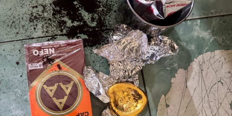 Petugas Cargo Bandara Sultan Thaha Jambi menunjukkan emas ilegal seberat 375 gram yang disamarkan di dalam kaleng kopi dan hendak dikirim ke Jakarta melalui jasa pengiriman barang. (Dok: Alpin)