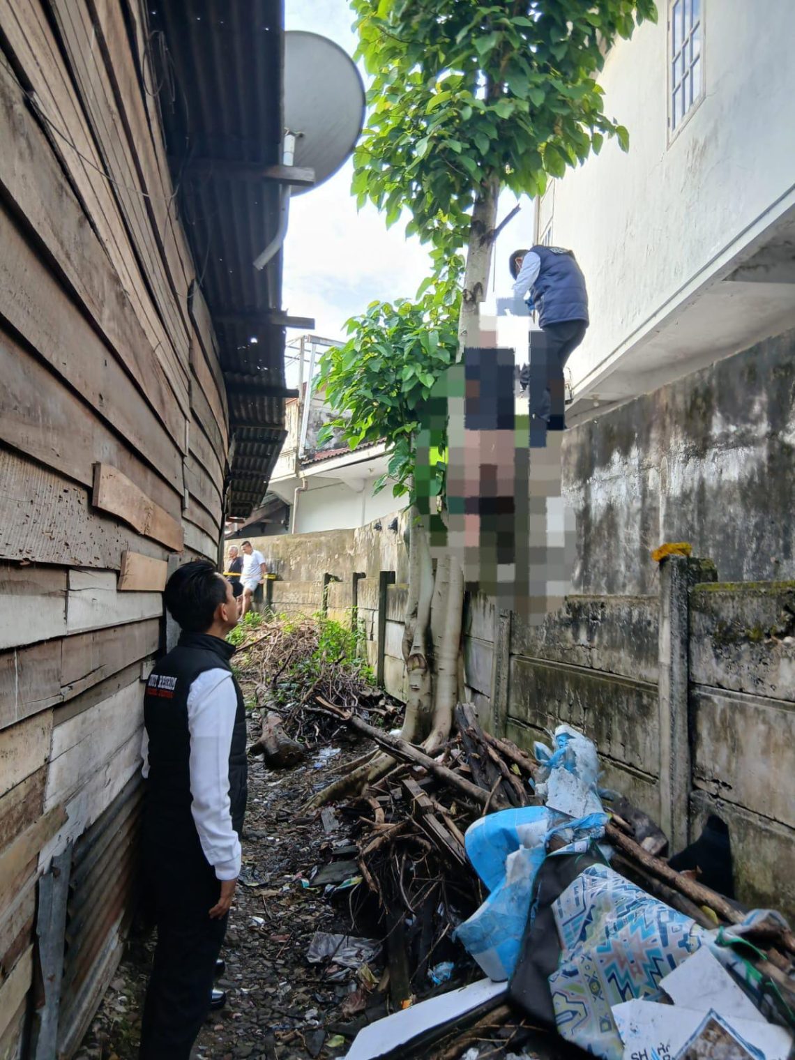 Petugas kepolisian saat melakukan evakuasi dan olah TKP penemuan jasad seorang pria yang tergantung di pohon di kawasan Jalan Prof. Dr. Sumantri Brojonegoro, Kecamatan Jelutung, Kota Jambi, Senin (11/5/2026). (Dok: Alpin)