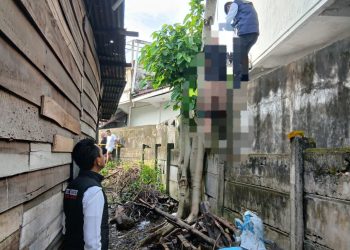 Petugas kepolisian saat melakukan evakuasi dan olah TKP penemuan jasad seorang pria yang tergantung di pohon di kawasan Jalan Prof. Dr. Sumantri Brojonegoro, Kecamatan Jelutung, Kota Jambi, Senin (11/5/2026). (Dok: Alpin)