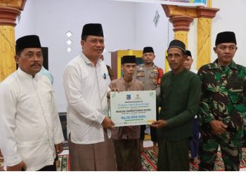 Wakil Bupati Tanjab Barat Dr. H. Katamso menyerahkan bantuan secara simbolis kepada pengurus Masjid Zahratussaadah saat Safari Ramadhan di Desa Sungai Landak, Kecamatan Senyerang, Kamis (5/3). (Dok: Diskominfo Tanjab Barat)