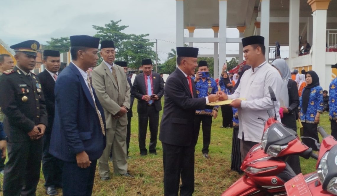 Wakil Bupati Merangin A. Khafidh menyerahkan secara simbolis sepeda motor dinas kepada perwakilan Da’i serta piagam penghargaan kepada siswa berprestasi usai upacara Hardiknas di halaman Kantor Bupati Merangin, Sabtu (2/5/2026). (Dok: Rudi)